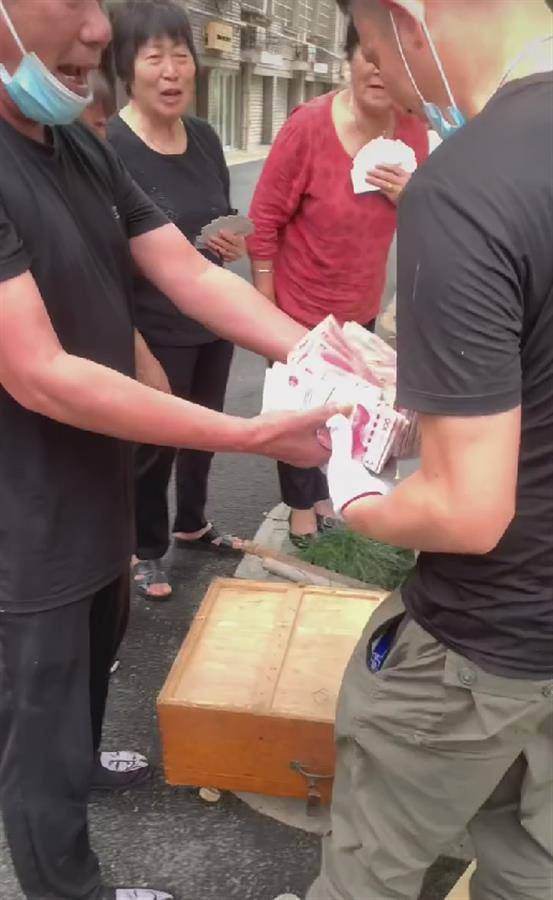 大爷摆摊自称送20万现金 当地回应
